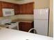 Compact kitchen featuring white appliances and ample wooden cabinetry at 770 Parkway Rd, Union City, GA 30291