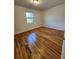 Well-lit bedroom featuring hardwood floors and a window offering outdoor views at 3125 Colonial Way # H, Atlanta, GA 30341
