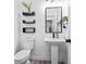 Half bathroom featuring pedestal sink, modern fixtures, decorative shelves, and tile flooring at 1514 Park Grove Dr, Lawrenceville, GA 30046