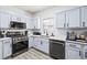 Bright kitchen featuring stainless steel appliances, light blue cabinets, and light hardwood flooring at 1514 Park Grove Dr, Lawrenceville, GA 30046