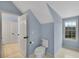 The bathroom with light blue walls has an open toilet area featuring a window at 1525 Thomas Rd, Canton, GA 30115