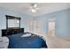 Bedroom with ensuite bathroom, neutral carpet, light blue walls, a ceiling fan, and a large mirror at 1525 Thomas Rd, Canton, GA 30115