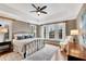 Spacious main bedroom with large windows, wood floors, tray ceiling, and a decorative ceiling fan at 1525 Thomas Rd, Canton, GA 30115