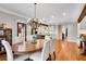 Open concept, showing dining room with hardwood floors, chandelier, and kitchen in the background at 1525 Thomas Rd, Canton, GA 30115