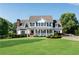 Traditional two-story home with a lush lawn and a welcoming front porch with black shutters and columns at 1525 Thomas Rd, Canton, GA 30115