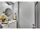 Elegant powder room featuring a white vanity, oval mirror, and decorative floral arrangement at 1525 Thomas Rd, Canton, GA 30115