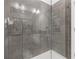 Close-up of walk-in shower showcasing gray tile, glass door, and chrome fixtures at 1756 Morningtide Ne Ln, Atlanta, GA 30324