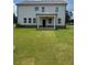 Backyard of a two-story home with a covered patio and an expansive green lawn at 1857 Kingsmere Run Dr, Loganville, GA 30052