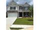Two-story home with brick facade, a two-car garage, and well-manicured lawn at 1857 Kingsmere Run Dr, Loganville, GA 30052