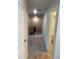 Upstairs hallway with carpet flooring leading to a full bathroom at 1857 Kingsmere Run Dr, Loganville, GA 30052