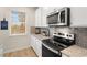 Well-lit kitchen with stainless steel appliances, granite countertops, and white cabinets at 1857 Kingsmere Run Dr, Loganville, GA 30052