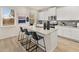 Bright kitchen features white cabinets, granite countertops, stainless appliances and seating at the island at 1857 Kingsmere Run Dr, Loganville, GA 30052