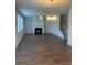 Open living room features a fireplace, fan, and a decorative chandelier at 1857 Kingsmere Run Dr, Loganville, GA 30052