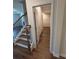 Carpeted stairs featuring natural wood handrail and black metal spindles at 1857 Kingsmere Run Dr, Loganville, GA 30052