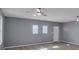 Open living room with wood-look floors, multiple windows, and neutral gray walls at 2401 Phillips Rd, Lithonia, GA 30058