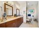 A bathroom with double sinks, wood cabinets, a large mirror, a toilet, and neutral paint is displayed at 3630 Peachtree Ne Rd # 1809, Atlanta, GA 30326