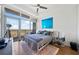 A bright bedroom with a large window, hardwood floors, area rug, and comfortable furniture is shown at 3630 Peachtree Ne Rd # 1809, Atlanta, GA 30326