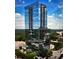 Contemporary glass high-rise with reflecting blue sky, surrounded by lush green trees at 3630 Peachtree Ne Rd # 1809, Atlanta, GA 30326