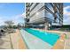 Outdoor lap pool surrounded by lounge chairs, with views of a modern high-rise building and blue skies at 3630 Peachtree Ne Rd # 1809, Atlanta, GA 30326