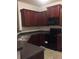 Cozy kitchen featuring wood cabinets, sleek black appliances, and granite countertops at 266 Valley Xing, Canton, GA 30114