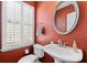 Half bathroom with a round mirror, single sink and plantation shutters at 3782 Chattahoochee Summit Se Dr, Atlanta, GA 30339