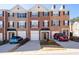 Charming brick townhome with a well-manicured front yard and driveway with cars at 3782 Chattahoochee Summit Se Dr, Atlanta, GA 30339