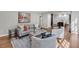 Open-concept living room with hardwood floors, a grey sofa, chairs, and view to the kitchen at 470 River Valley Rd, Atlanta, GA 30328