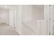 Hallway with neutral carpet, white walls, handrail, and multiple doorways at 300 Halibut Circle Cir, Covington, GA 30016