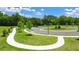 A lush green space with a sidewalk leading into a neighborhood with trees and manicured lawns at 8597 Secretariat Dr, Lithonia, GA 30058