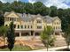 New construction townhomes featuring a yellow exterior, attached garages, and mature trees at 1983 American Way # 27, Kennesaw, GA 30144