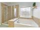 Bright bathroom with a separate shower and a soaking tub next to a decorative window at 301 Ridgewood Trl, Canton, GA 30115