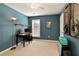 Modern bedroom with sleek desk, teal accent wall, electric guitar, and a bright window at 301 Ridgewood Trl, Canton, GA 30115