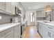 A modern kitchen boasts gray cabinets, stainless steel appliances, a tile backsplash and quartz countertops at 3085 Jackson St, Hapeville, GA 30354