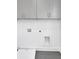 Laundry room featuring upper cabinets, a window and a sink with black and white flooring at 3085 Jackson St, Hapeville, GA 30354