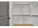 Walk-in closet with white shelving and wood floors; an open door is to the left at 3163 Old Jonesboro Rd, Hapeville, GA 30354