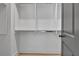 View of a walk-in closet with white shelving and wood floors; grey door to the right at 3163 Old Jonesboro Rd, Hapeville, GA 30354