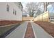 Long driveway lined with pine straw leads to a home with a fenced-in backyard at 3163 Old Jonesboro Rd, Hapeville, GA 30354