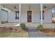 Inviting front porch featuring a red door, ceiling fans and crisp, white columns at 3163 Old Jonesboro Rd, Hapeville, GA 30354