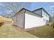 Side view of home featuring a two-car garage and a yard with a wooden privacy fence at 3163 Old Jonesboro Rd, Hapeville, GA 30354