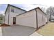Exterior view of a two-car garage with white siding, concrete driveway, and landscape features at 3163 Old Jonesboro Rd, Hapeville, GA 30354