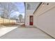 View of exterior two-car garage with a red door, concrete driveway, and landscaping at 3163 Old Jonesboro Rd, Hapeville, GA 30354