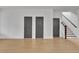 Hallway with grey doors and light wood floors, and access to the staircase at 3163 Old Jonesboro Rd, Hapeville, GA 30354