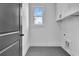 Bright laundry room featuring white cabinets, black hardware, patterned flooring, and a window for natural light at 3163 Old Jonesboro Rd, Hapeville, GA 30354