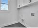 Bright laundry room featuring cabinets, tile floor and modern convenience at 3163 Old Jonesboro Rd, Hapeville, GA 30354