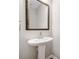 Elegant powder room with pedestal sink and decorative mirror at 495 Duval Dr, Alpharetta, GA 30009
