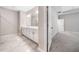 Bathroom featuring double sinks, a large mirror, ceramic tile flooring, and an open doorway at 495 Duval Dr, Alpharetta, GA 30009