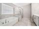 Elegant bathroom featuring a soaking tub, a separate glass shower, and tile flooring at 495 Duval Dr, Alpharetta, GA 30009