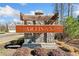 Stone sign for the Artisan community with landscaping and clear blue skies at 495 Duval Dr, Alpharetta, GA 30009