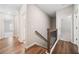 Bright hallway with hardwood floors and modern staircase leads to bedrooms and bathrooms at 495 Duval Dr, Alpharetta, GA 30009