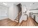 Modern kitchen and staircase area featuring hardwood floors, stainless steel appliances and white cabinets at 495 Duval Dr, Alpharetta, GA 30009